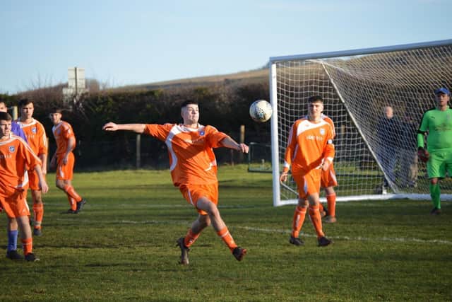 Left-back Josh Wade looks to clear his lines for Heslerton.