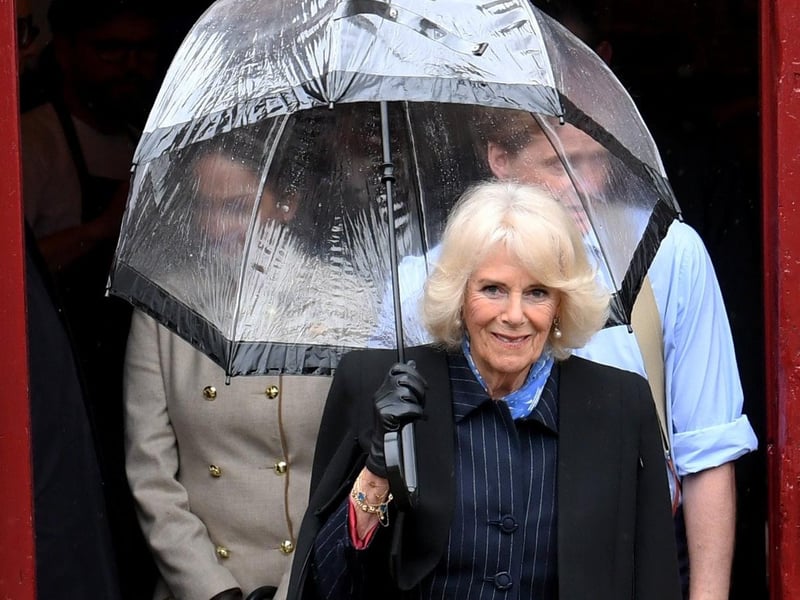 Queen Consort still smiling despite the rain.