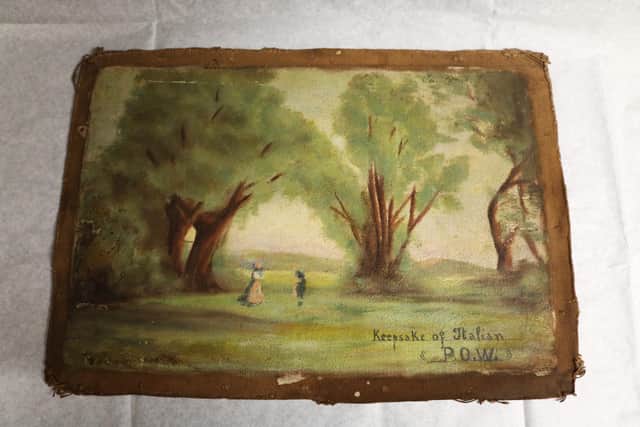 The donated painting is inscribed with “Keepsake of Italian P.O.W.”
