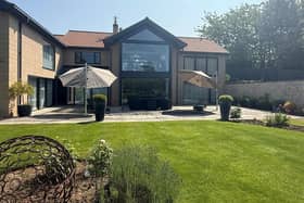 A rear view of the property from its landscaped garden.
