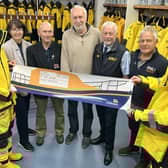 Whitby RNLI crew accept a cheque from Facing the Waves Director Antony Bellekom. picture: RNLI/Ceri Oakes