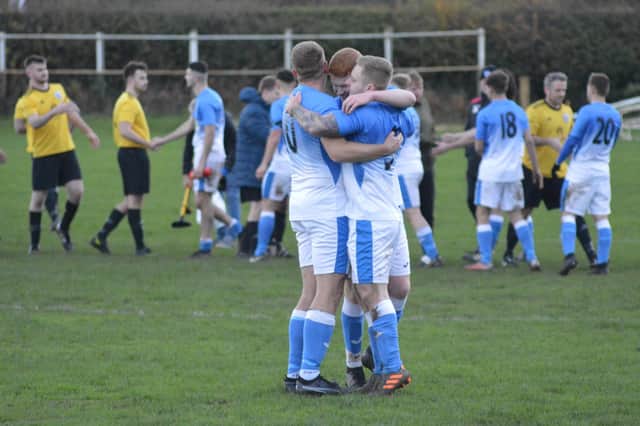 Heslerton's Nathan Poole (right) is congratulated by Gareth Driver and Ben Flinton following his decisive penalty shootout kick.