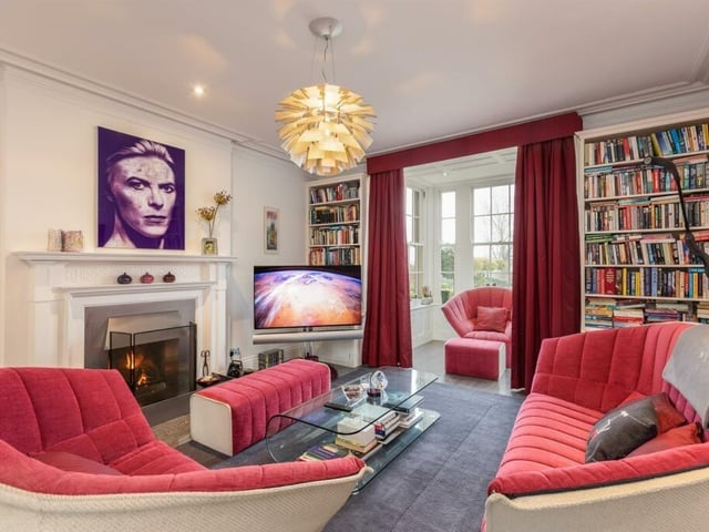 The library with its lovely fireplace, fitted bookshelves and glazed reading room with views over the grounds.