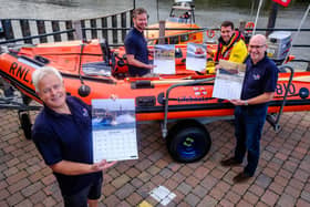Whitby RNLI Museum Curator Neil Williamson, Community Manager Alex Maskery, coxswain Richard Dowson and Nick Chambers (Visits Team) with the 2027 calendar at Whitby Lifeboat Station. photo: Ceri Oakes / RNLI