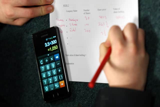 A pupil doing their maths homework as children who are good at maths at age 10 earn more later in life, new research suggests.