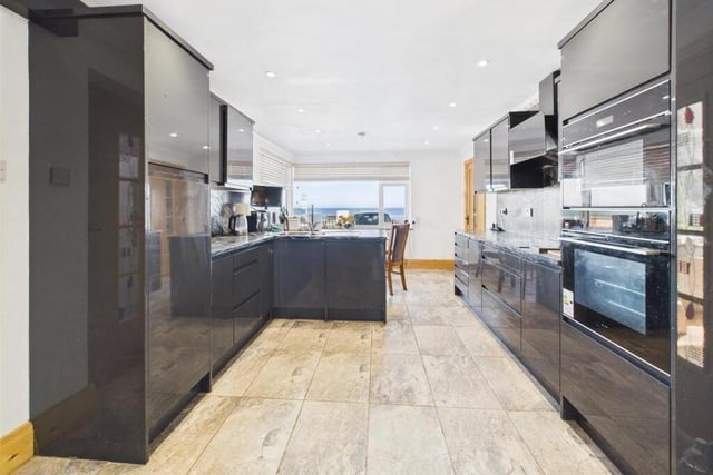 A sleek and well equipped modern kitchen with diner has views over the sea.