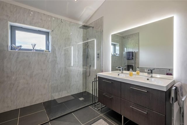 A stylish shower room, with twin washbasins and vanity units.
