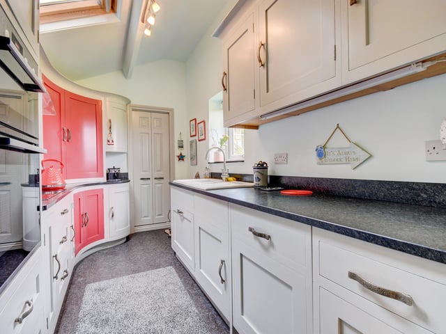 The curved galley kitchen has an extensive range of units.