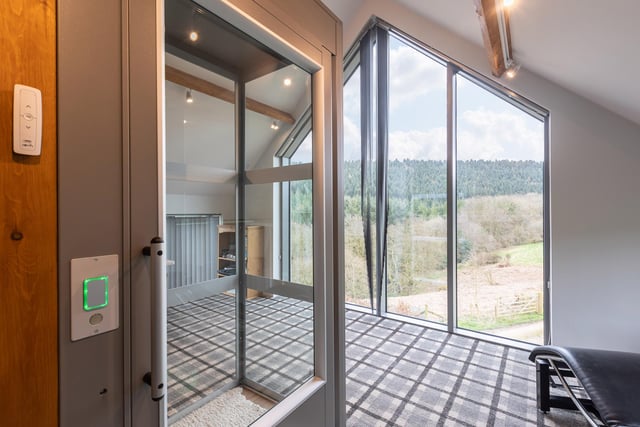 A wall of windows maximises the far-reaching views of countryside and woodland.