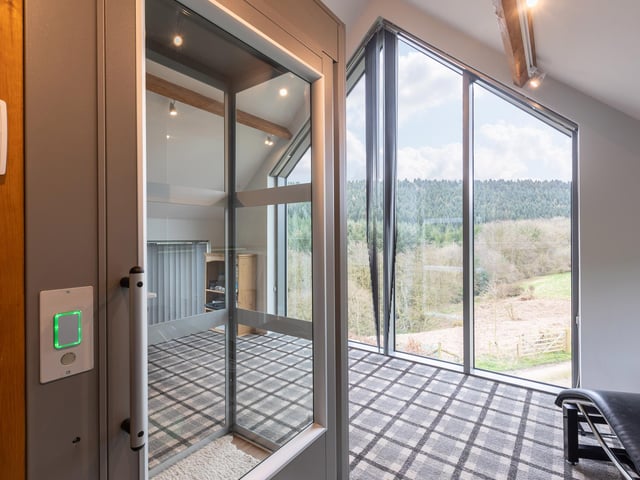 A wall of windows maximises the far-reaching views of countryside and woodland.