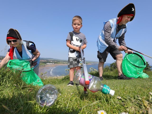 Heather and Kev Hay pick up litter with one of the little volunteers.