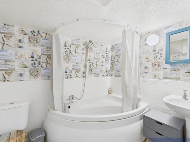 The bathroom has both bath and overhead shower.