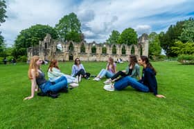 Visitors to York enjoying the warm weather while relaxing in York Museum Gardens.