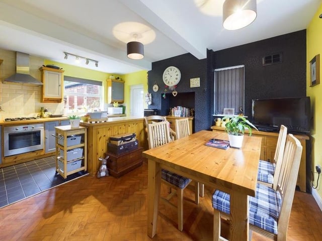 Parquet flooring and oak worktops feature in this property's stylish kitchen with diner fitted with units, an electric cooker and gas hob.