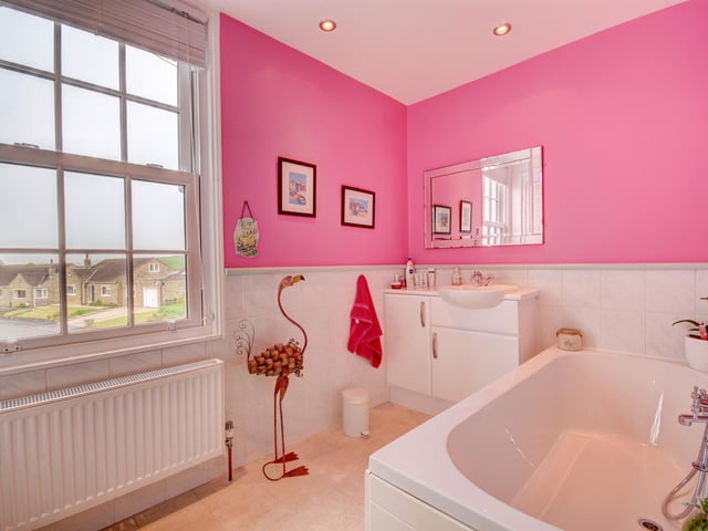A sizeable bathroom with double-ended bath and wash basin vanity unit.