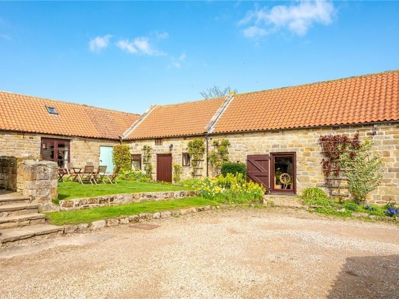 The farmhouse, barn and buildings are arranged around a central garden space.