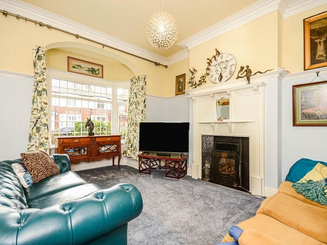 The lounge has a deep bay window, and a feature fireplace, with period decorative detail.