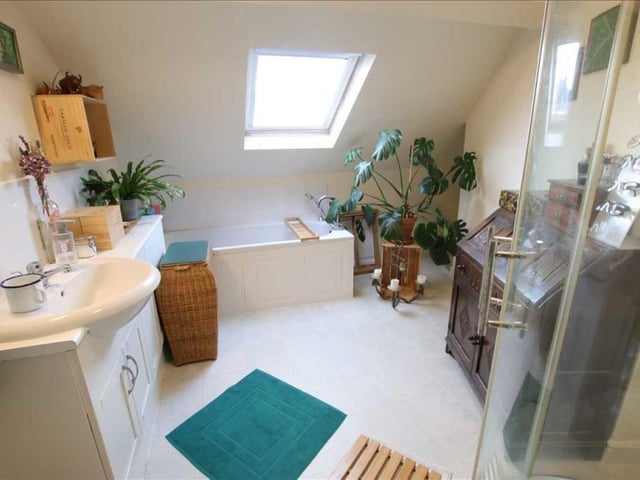 The stylish bathroom, with both bath and separate shower cubicle, has a wash basin within fitted units.