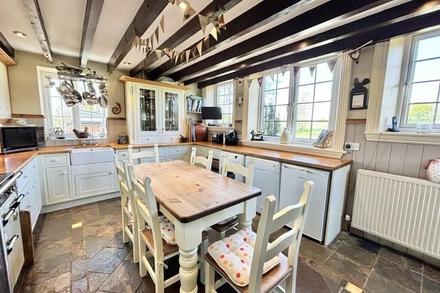 A traditional style dining kitchen has a range style cooker, and lovely views from its windows.