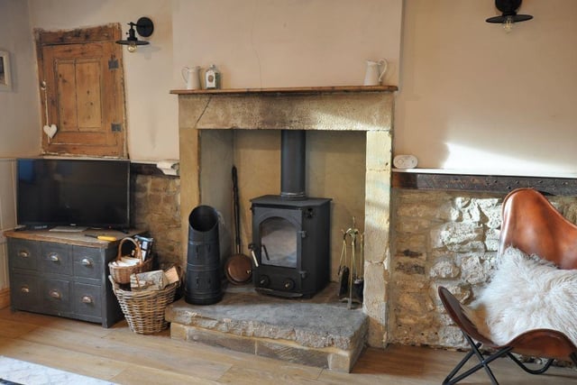 A lovely old stone fireplace houses a woodburner stove.