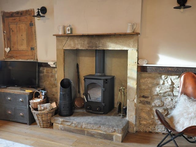 A lovely old stone fireplace houses a woodburner stove.