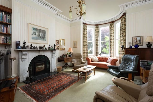 A spacious reception room with feature fireplace and bay window.