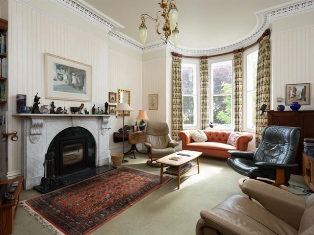 A spacious reception room with feature fireplace and bay window.