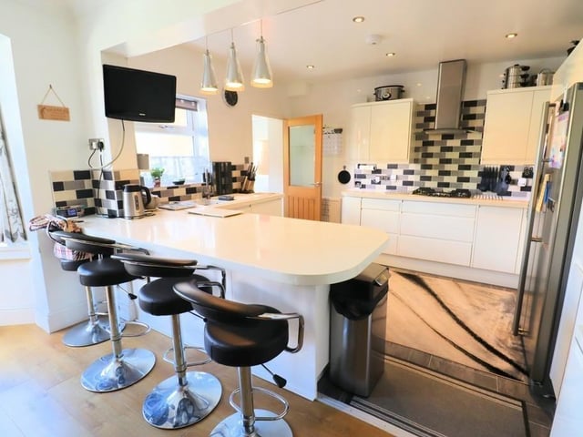 This breakfast kitchen has modern units, with a wine cooler, dishwasher, American fridge freezer, double electric oven with five ring gas hob and extractor, and granite worktops.