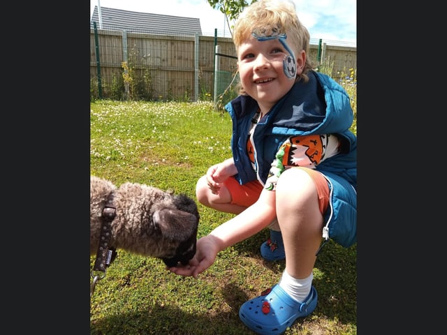This little tyke is making new animal friends with some fab football themed facepaint on!