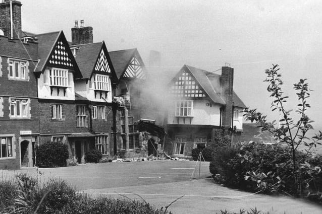 A puff of dust rises from the debris as the hotel collapses.