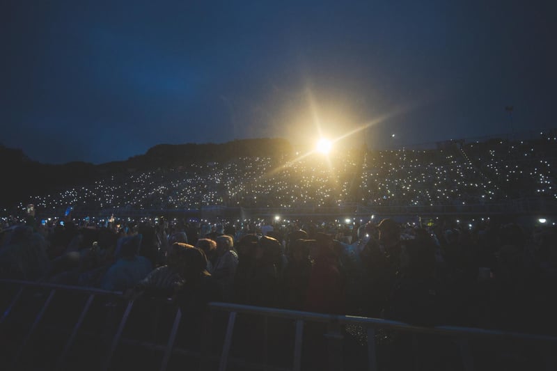 Phones light up the darkness as fans capture the moment.