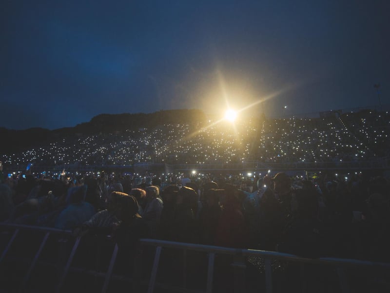 Phones light up the darkness as fans capture the moment.