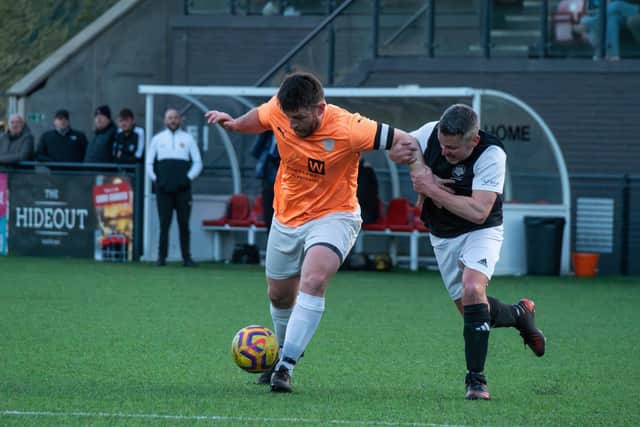 Edgehill skipper Joe Gallagher holds off a Kirkdale United player.