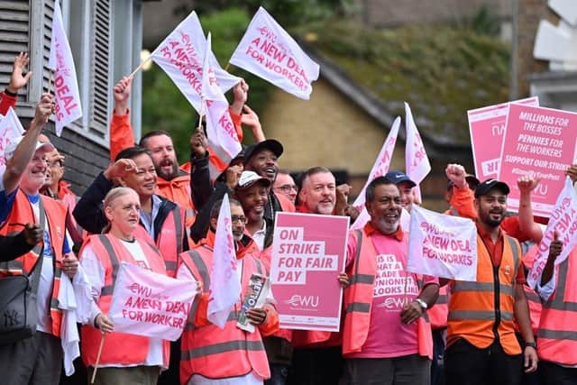 Royal Mail postal workers hold placards and chant slogans as they stand on a picket line outside a delivery office, in north London, on September 8, 2022 during a strike. - The Royal Mail postal workers will be on strike on September 8 and September 9 to ask for a pay rise taking into account both the cost-of-living crisis and the contribution of postal workers during the Covid pandemic according to the Communication Workers Union. (Photo by Justin TALLIS / AFP) (Photo by JUSTIN TALLIS/AFP via Getty Images)