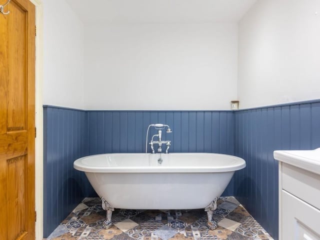 The house bathroom includes a free standing bath tub.
