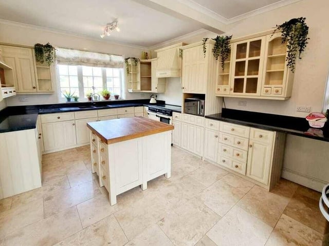 The beamed kitchen with diner has fitted units with a central island.