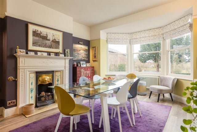 Another lovely reception room with bay window and attractive fireplace.