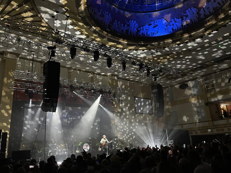The Lathums' frontman Alex Moore performing an intimate song to the crowd with just himself, his guitar and a discoball.