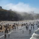 Sunseekers on the beach as thick sea fret in Whitby lifts over Whitby Regatta. 
Picture Tony Johnson.