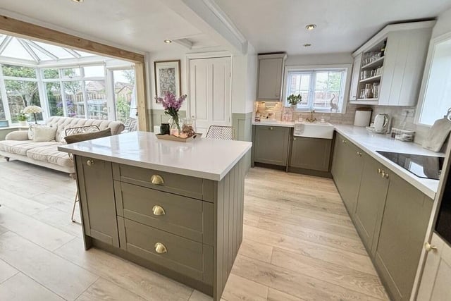 The contemporary style kitchen is open plan to a conservatory.