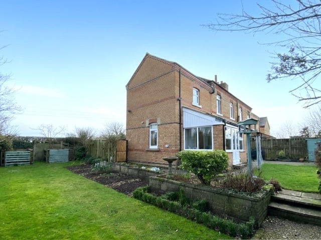 An attractive lawned garden wraps around the semi-detached cottage.