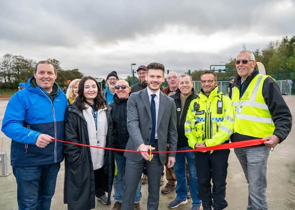 Councillor Keane Duncan, cutting the ribbon, surrounded by representatives from the council, town council, police and Filey Lions Club.