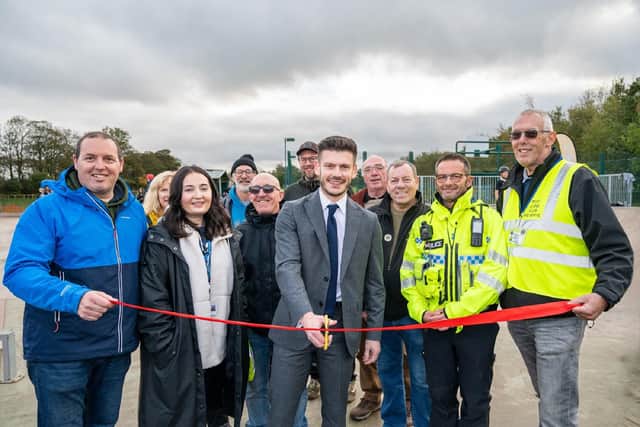 Councillor Keane Duncan, cutting the ribbon, surrounded by representatives from the council, town council, police and Filey Lions Club.