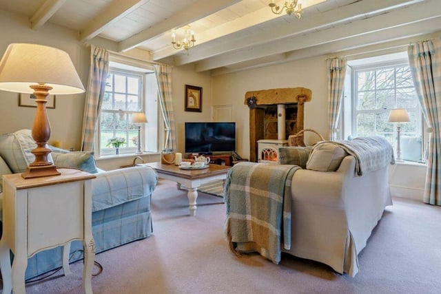 A stone fireplace with a stove warms the lounge, while large windows admit plenty of natural light and give lovely garden views.