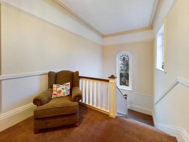The first floor landing has seating space, with an original stained glass window.