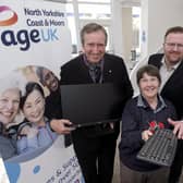Cllr Guy Smith presents a PC to Age UK volunteer Georgie Elliott with Chief Exec Neil Bradbury.