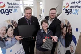 Cllr Guy Smith presents a PC to Age UK volunteer Georgie Elliott with Chief Exec Neil Bradbury.