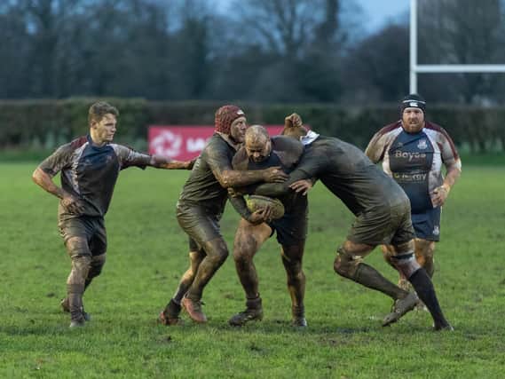 Hosts Malton & Norton and Scarborough battle it out in the mud, Jake Lyon being tackled by Malton.