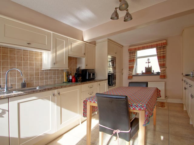 The beamed breakfast kitchen has a range of fitted units.