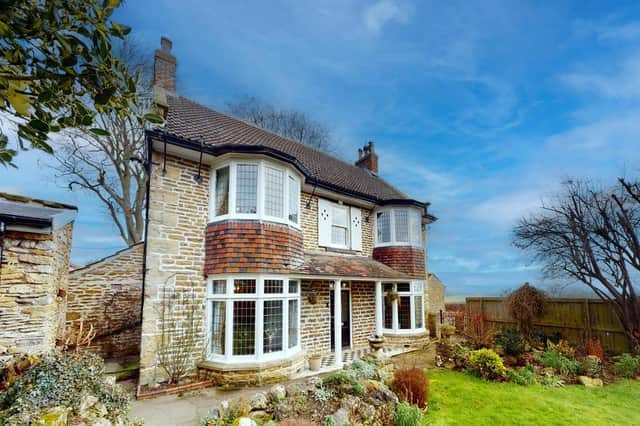 The detached village property has three reception rooms, five bedrooms and a lawned garden with views.